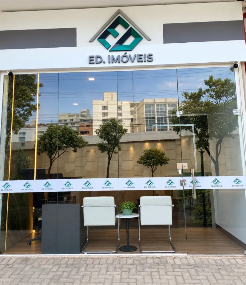Fachada da ED Imóveis, com o logo e a vitrine de vidro
